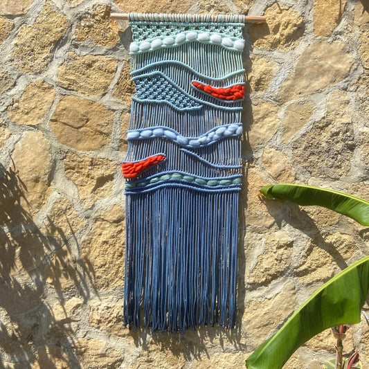 Tapiz 117 - El Murmullo del Mar Rojo - Tapiz de macramé azul con olas y acentos rojos – decoración de pared artesanal inspirada en el mar