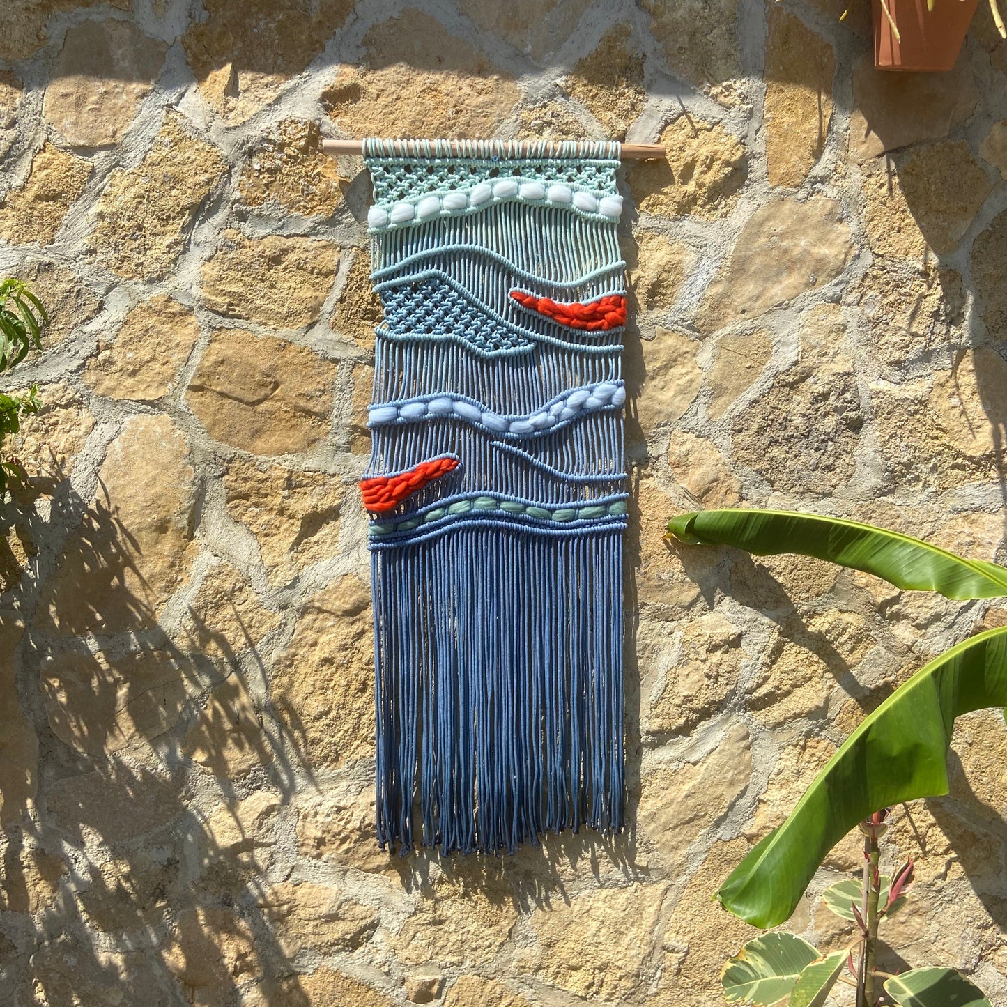 Tapiz 117 - El Murmullo del Mar Rojo - Tapiz de macramé azul con olas y acentos rojos – decoración de pared artesanal inspirada en el mar