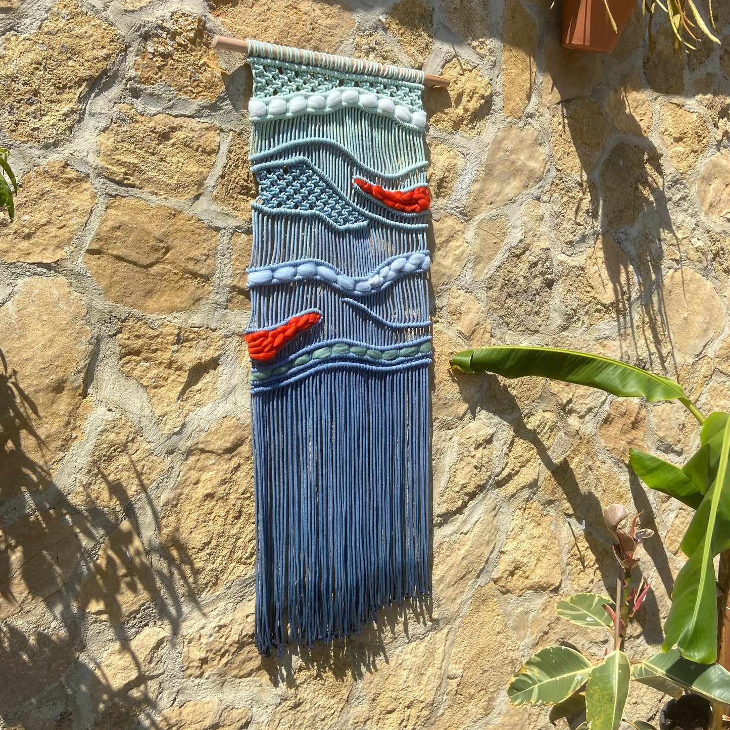 Tapiz 117 - El Murmullo del Mar Rojo - Tapiz de macramé azul con olas y acentos rojos – decoración de pared artesanal inspirada en el mar