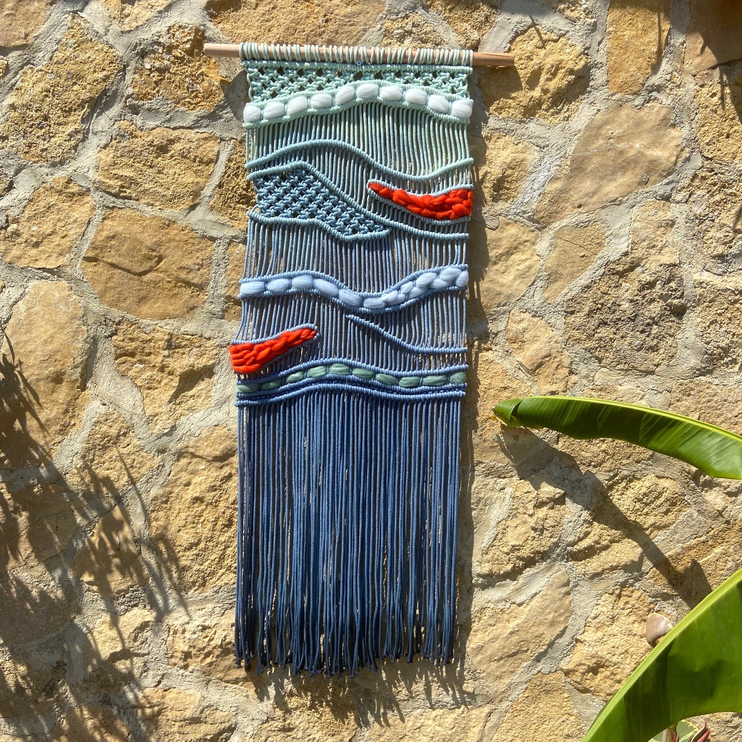 Tapiz 117 - El Murmullo del Mar Rojo - Tapiz de macramé azul con olas y acentos rojos – decoración de pared artesanal inspirada en el mar
